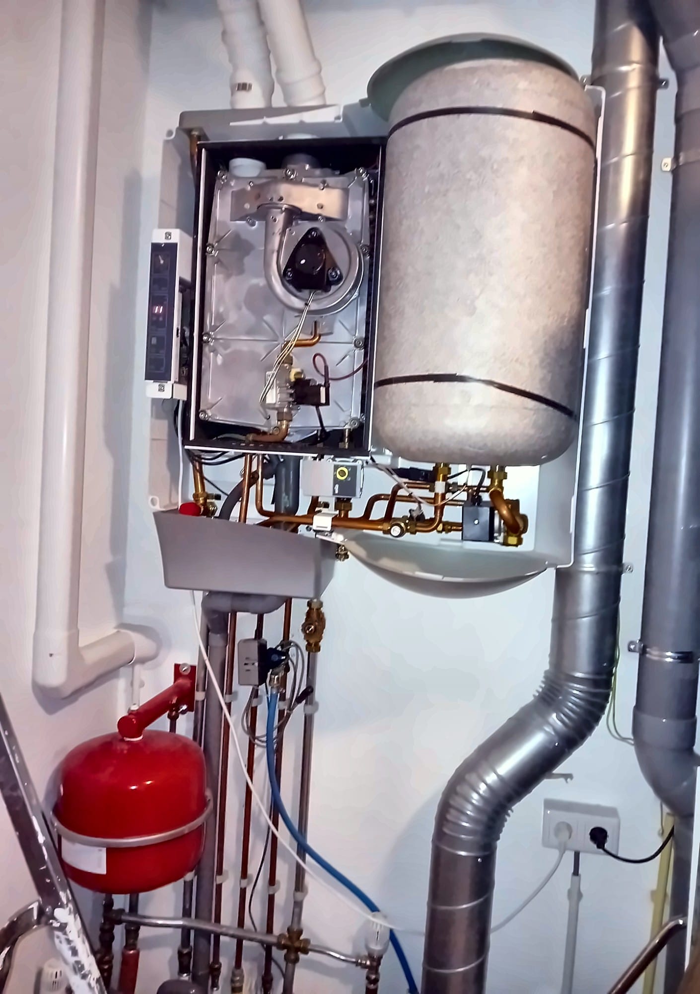 Geopende CV-ketel naast een geïsoleerd boilervat, met een rood expansievat eronder
